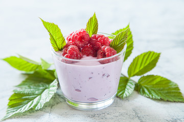 yogurt with raspberry in a glass on a table, selective focus