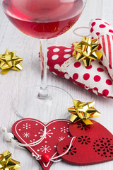 glass of red wine and toy hearts close-up