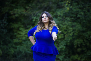 Young beautiful plus size model in blue dress outdoors, xxl woman on nature