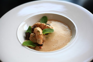 Scampi ragout with potato cream, bisque and black morels