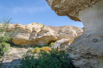 Natural rock formations and sparse vegetation at Lake Arco in Angola's Namib Desert