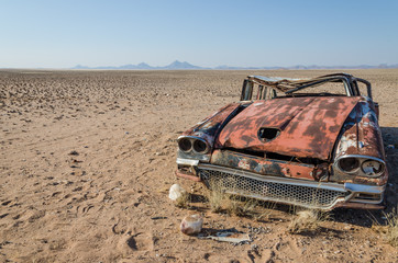 Fototapeta premium Wreck of classic saloon car abandoned deep in the Namib Desert of Angola