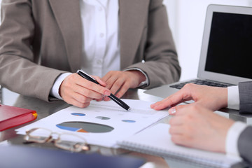 Group of business people at meeting  discussing financial results. Women pointing into laptop computer monitor