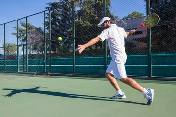 Tuinposter Professional tennis player man playing on court © pablobenii