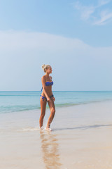 Young slim blonde swimming in sea