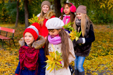 group of girls in autumn park with leafs