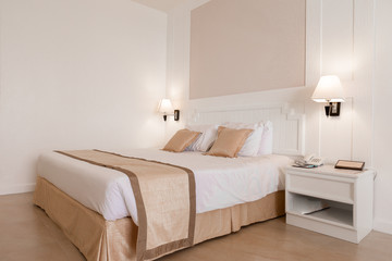 Fototapeta na wymiar White bedroom with a king size bed and pillows.