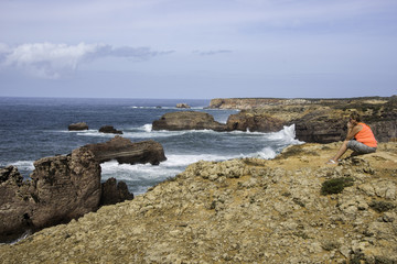 woman enjoy the seaview sitting on the ground