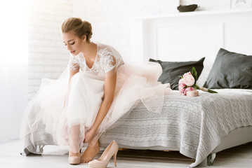 Beautiful bride sitting in the white colored room