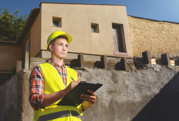 Construction worker writes the clipboard data. construction background.