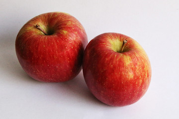 dos manzanas rojas sobre fondo blanco