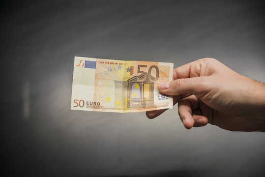 fifty euro banknote in male hand close up. Male hand holding a 50 euros