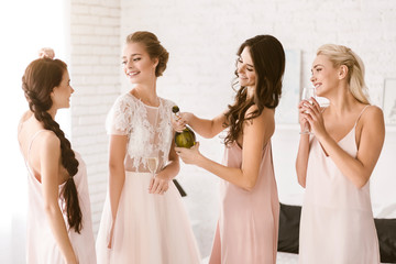 Smiling bride and bridesmaids having fun at home