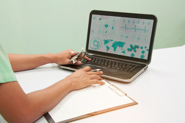 Doctor working with computer notebook at desk