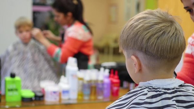 haircut of a child with scissors in the barbershop