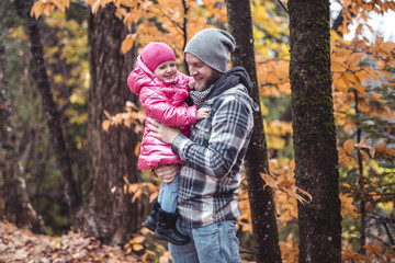 Daughter with dad walking in the autumn forest