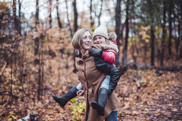Portrait of a smiling young woman with a little girl in autumn