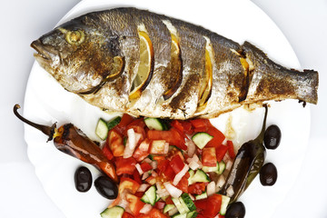 Cooked fish sea bream fish with lemon, parsley,garlic.