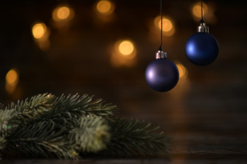 Two blue Christmas ball and spruce branches on the background of beautiful bokeh.