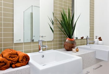 Modern washing area, including an orange color towel with silver
