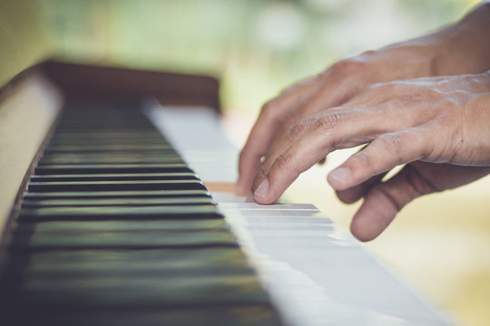 Close up man hand musician playing piano.