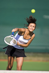 Tennis player volleys ball in frame