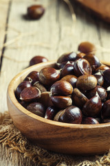 Chestnuts in bowl, old wooden background, selective focus