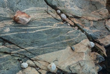 close up of large cracked boulders with smaller rocks in fissure