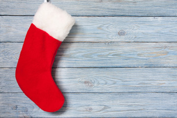 Obraz na płótnie Canvas Red Christmas sock on the blue wooden background