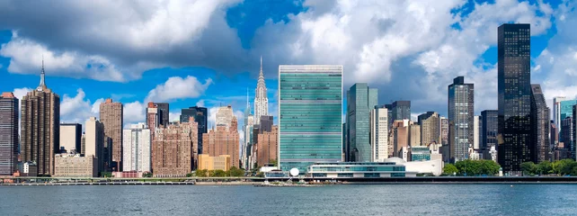 Foto op Plexiglas New York De skyline van midtown Manhattan, New York City met een dramatische bewolkte hemel