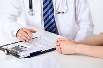 Fototapeta premium Hand of doctor reassuring her female patient. Medical ethics and trust concept