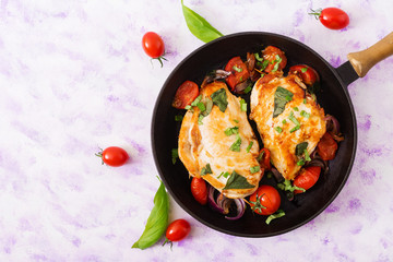 Grilled Chicken breast stuffed with tomatoes, garlic and basil in pan. Top view