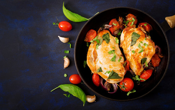 Grilled Chicken breast stuffed with tomatoes, garlic and basil in pan. Top view