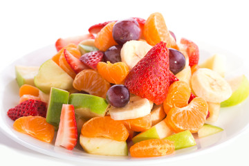 Colorful fruit salad heaped on white plate