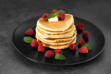 Plate full of tasty pancakes with raspberries