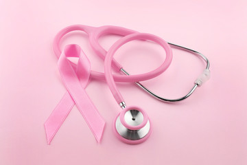 Stethoscope with pink ribbon on color background. Breast cancer concept