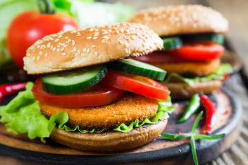 Fishburger with vegetables on a bun with sesame seeds