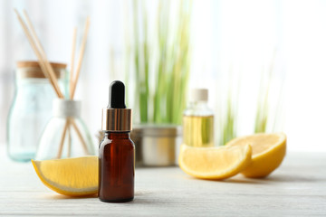 Beautiful spa composition with lemon essential oil on white wooden table, closeup
