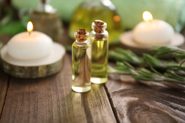 Obraz na płótnie Canvas Bottles of rosemary essential oil on wooden table
