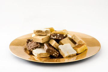 Christmas nougat on a golden plate isolated on white background
