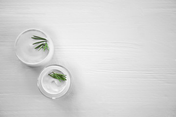Cream and rosemary on wooden background