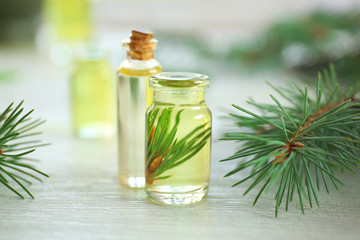 Bottles of pine essential oil on wooden table