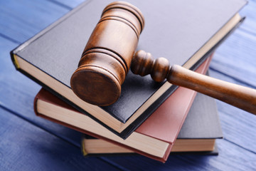 Gavel and books on wooden background