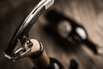 Bottle of wine and corkscrew over wooden background - 127839488