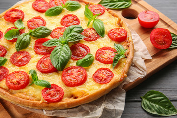Fresh tasty pizza Margarita on wooden tray, closeup