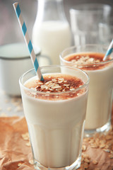 Delicious milkshake with chocolate in a glass on table, closeup