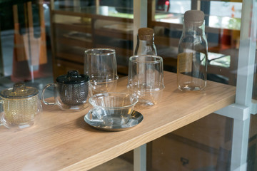 Abstract background of glass tea cups and kettles on shelf for sale, selective focus