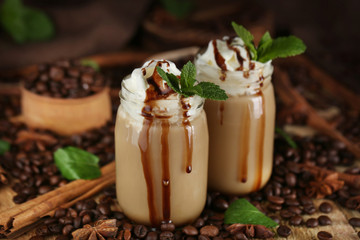 Delicious chocolate milk dessert with coffee beans and mint on wooden background