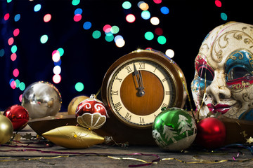 New Year decorations and clock on the background of colored ligh