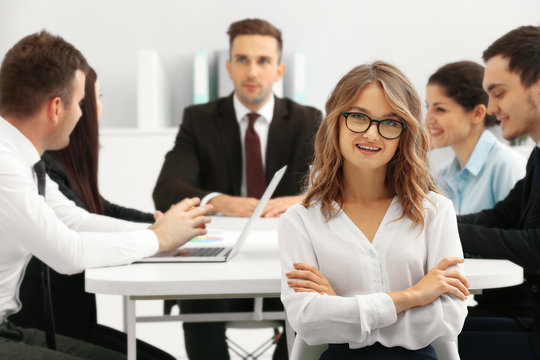 Businesswoman with colleagues on background at office